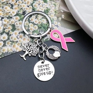 Macro detail of antique silver keychain with tree of life, wing heart and never give up tag