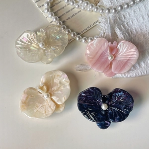 Elegant acetate orchid flower hair clips with pearl centers in various colors on white background