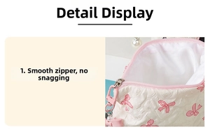 Close-up of smooth pink zipper with pearl pendant on bow pattern makeup bag