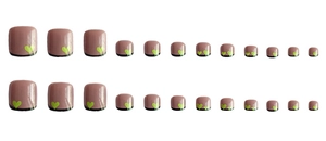 Detail view of square mauve press-on toenails with neon green heart patterns