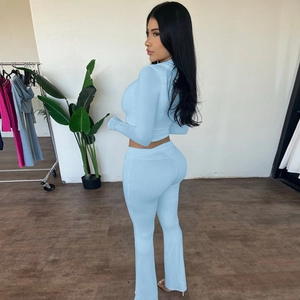 Detail of light blue two-piece slim fit set with long sleeve crop top and flared trousers
