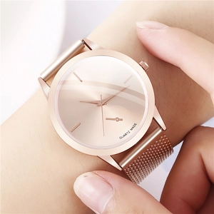 Close-up of rose gold minimalist quartz watch with Milanese mesh metal strap on wrist