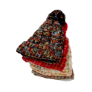 Close-up of colorful thick knit beanies with pom-poms in various stacked colors