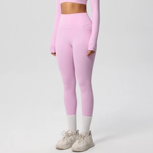 Close-up of pink high-waisted yoga pants with functional side pockets and seamless texture