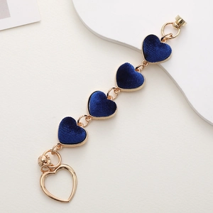 Detailed view of DIY phone charm with dark blue plush heart pendants and gold chain
