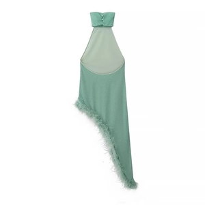 Detailed view of shimmering green halter dress featuring feather fringe and asymmetric hem
