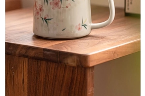 Detail of peach blossom ceramic mug showing natural wood grain texture of a table