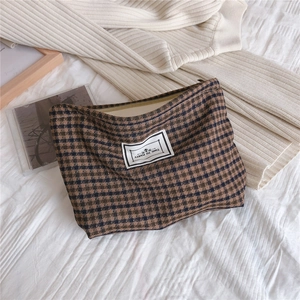Detailed view of British plaid fabric storage bag with zipper and decorative label