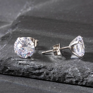 Macro detail of 7mm round cubic zirconia stud earring with 4-claw steel setting on stone