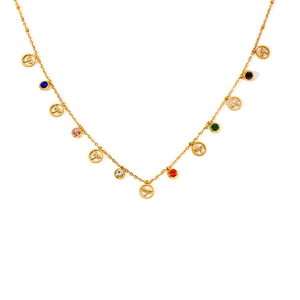 Detail of gold necklace featuring colorful zircon stones and dragonfly pendant charms