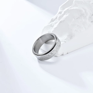 Close-up of Eye of Horus spinner ring in polished steel on a white stone base