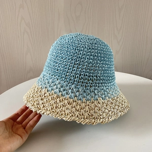 Dettaglio ravvicinato del cappello di paglia intrecciato bicolore blu e beige