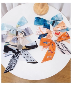 Flat lay of satin hair ribbons in multiple colors including blue, orange and lilac patterns