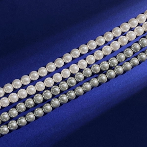 Elegant beaded pearl necklace with white and grey beads over a royal blue background