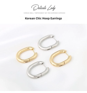 Flat oval U-shaped earrings in polished gold and silver steel on white silk