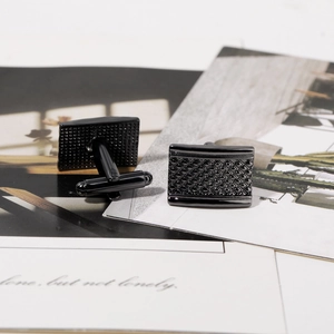 Macro shot of black square cufflinks featuring intricate diamond pattern textures
