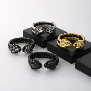 Dettaglio di bracciali a testa di leone in oro, argento e nero su supporti moderni