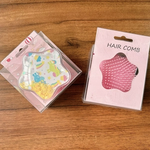 Macro shot of pink star-shaped hairbrush with unicorn patterns and glitter sand in box