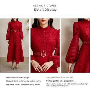 Détails d'une robe en dentelle rouge avec col montant, boutons et boucle en cristal
