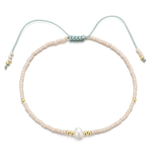 Détail du bracelet en perles beige avec perle centrale et cordon tressé réglable pratique