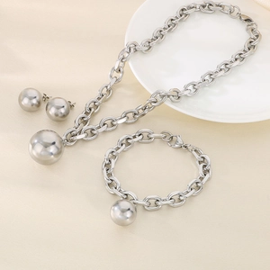 Detailed close-up of chunky silver stainless steel jewelry set with ball pendants