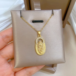Gold stainless steel necklace with Virgin Mary zircon pendant shown on silk background