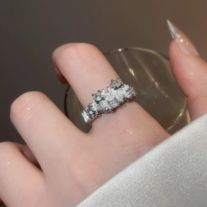 Detailed view of silver irregular textured ring with zircon stones worn on finger