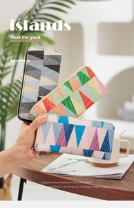 Detailed view of long wallets featuring geometric triangle patchwork and gold zippers
