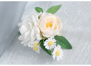 Close-up of white rose and champagne peony wrist corsage for wedding celebration