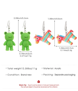 Detailed view of flocked green frog and colorful acrylic pinata earrings with measurements