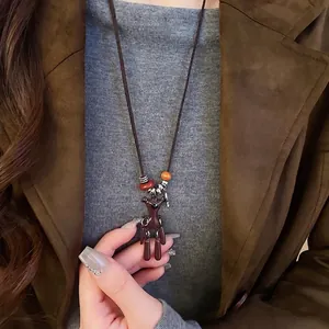 Cute brown bear pendant necklace with retro beads on a model wearing an autumn coat