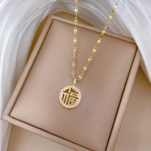 Gold plated stainless steel necklace with diamond-encrusted Fu character pendant on display