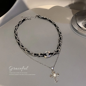 Double-layer necklace with black leather cord, rhinestone buckle, and silver cross pendant