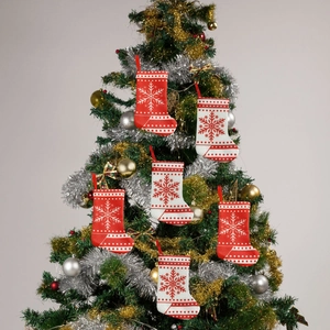 Close-up of six mini Christmas stockings with snowflake patterns hanging on a tree