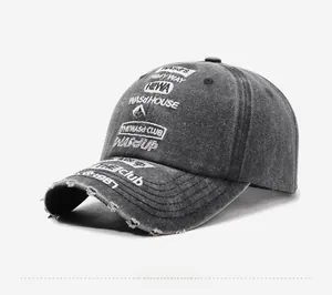 Detail view of washed grey baseball cap with distressed brim and multi-text embroidery