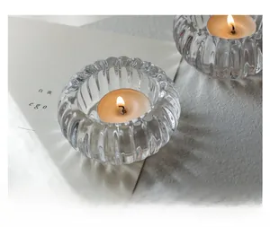 Détail de photophores en verre à rayures verticales avec une bougie allumée à l'intérieur