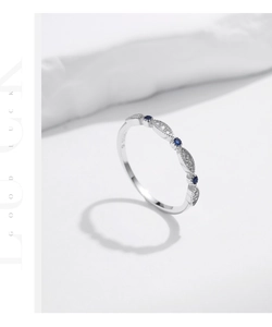 Detailed close-up of s925 silver bow ring with sparkling blue and white crystals