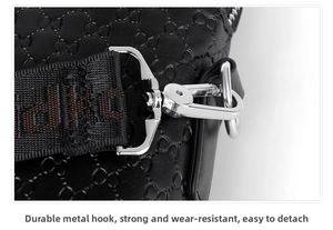 Close-up of embossed leather business bag with silver metal hook and woven strap