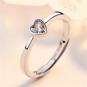 Close-up of elegant silver couple ring with a heart-shaped gemstone and polished band