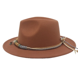 Dettaglio cappello fedora marrone con ciondolo a stella e fascia etnica intrecciata