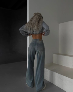 Détail macro du jean taille haute gris foncé à jambes larges montrant la texture du denim
