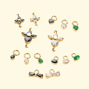 Macro view of gold plated stainless steel pendants with clover and star zircon inlays