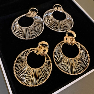 Detail of gold and silver woven hollow hoop earrings on black velvet jewelry box tray