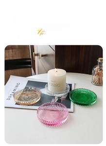 Dettaglio di vassoi per candele in vetro con strisce radiali in ambra, verde e rosa