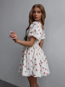 Detail of white square neck puff sleeve dress with red cherry print and smocking