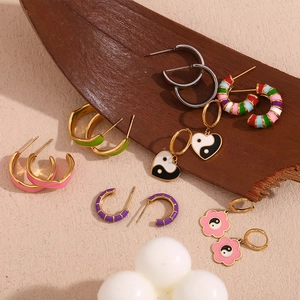 Close-up of assorted 18K gold plated enamel earrings with heart and floral motifs