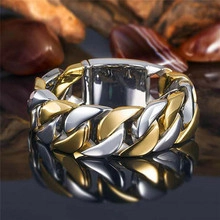 Macro view of two-tone hip hop cuban chain ring on reflective dark surface