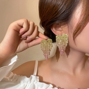 Close-up of heart tassel earrings with pink gradient rhinestones on model