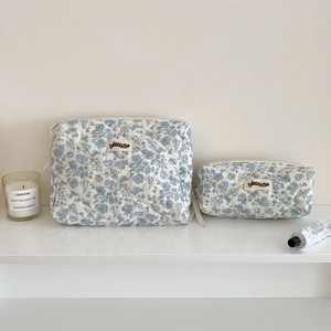 Quilted blue floral cosmetic bags in large and small sizes with zipper closure