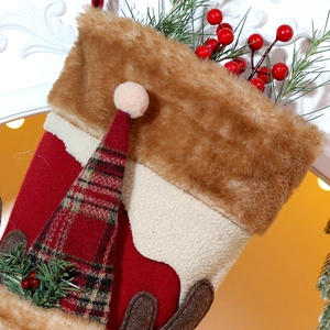 Detail of plush Christmas stocking with brown faux fur trim and reindeer decoration